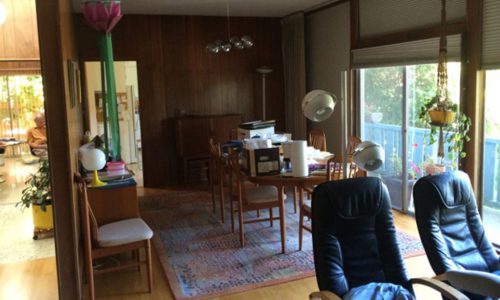 Cozy dining room with wooden furniture and a large window letting in natural light.