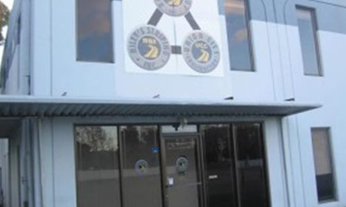 Front view of a building with a large circular emblem above the entrance.